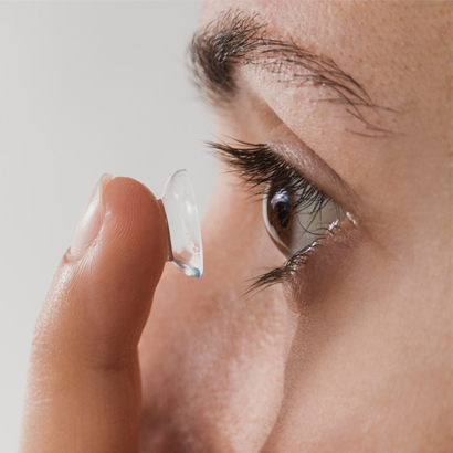 Contact Lens Being Inserted Into Brown Eye.