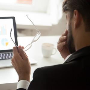 Man Rubbing Eyes In Front Of Laptop.