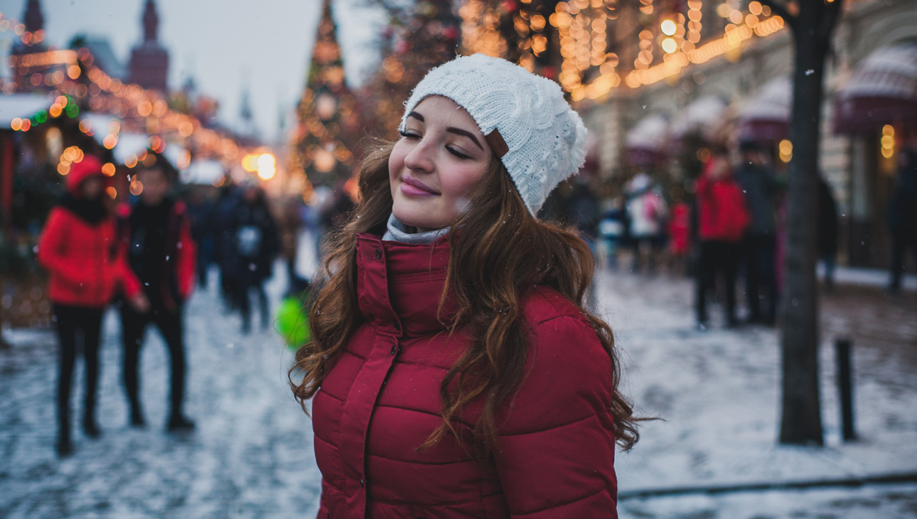 Woman Standing With Her Eyes Closed At A Christmas Market.