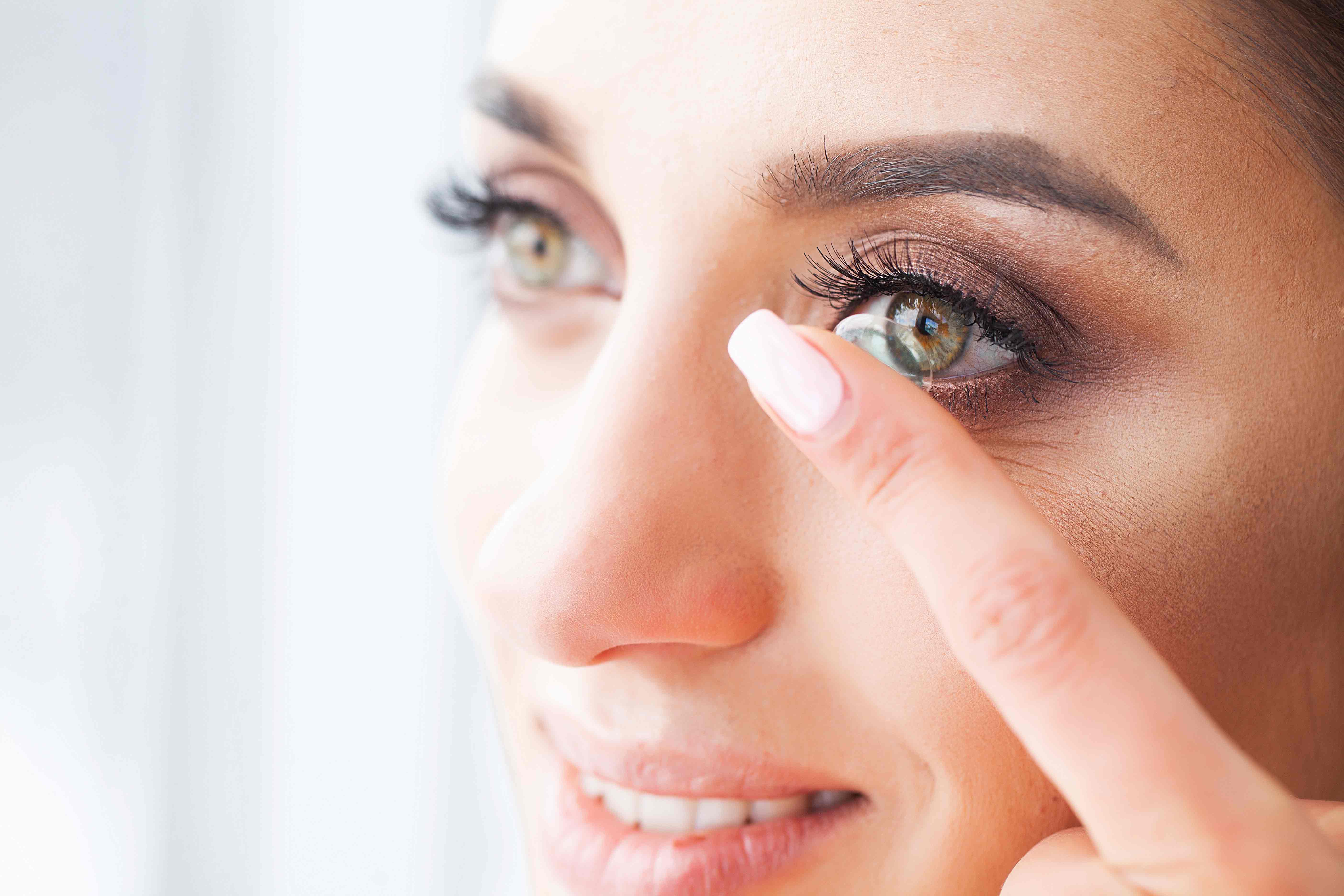 Woman Inserting Contact Lens.